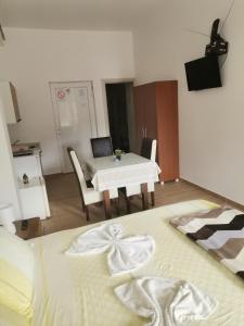um quarto com uma mesa e uma cama com um cobertor em Apartmani Lazić em Ribarska Banja