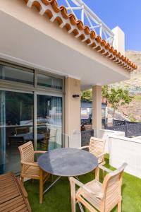 patio ze stołem i krzesłami przed domem w obiekcie Mini Suite 35 qm w mieście Calera