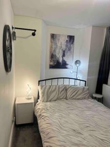 a bedroom with a bed and a lamp on a night stand at The Mews, private parking included, Windermere in Windermere