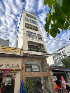 a tall white building with windows on top of it at Ana's House in Quy Nhon