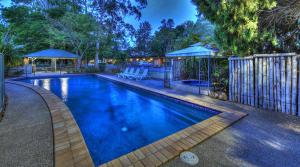 a swimming pool in a yard with a fence at All Seasons Country Lodge in Taree