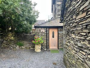 a building with a wooden door and a flower pot at The Mews, private parking included, Windermere in Windermere