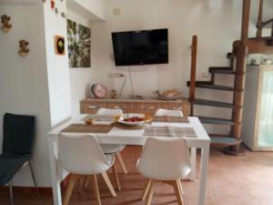 a dining room with a white table and chairs at Bnb Peter Pan in San Martino dʼAgri