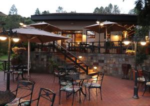an outdoor patio with tables and chairs and umbrellas at Little Switzerland Resort by Dream Resorts in Ethels Drive