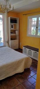 1 dormitorio con cama y ventana en Sous les oliviers, en Tourrettes