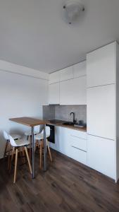 a kitchen with white cabinets and a table and chairs at Monty studio in Bar