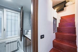a stairway leading to a bathroom with red stairs at A cuxinn-a studiò Maddalena - GenovaInRelax in Genova