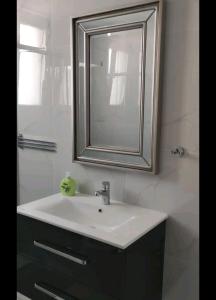 a bathroom with a white sink and a mirror at Nice flat in Tseri