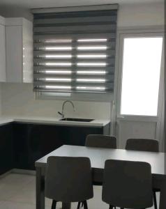 eine Küche mit einem Tisch, Stühlen und einem Waschbecken in der Unterkunft Nice flat in Tseri