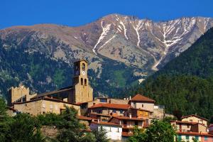 a town with a clock tower in front of a mountain at LE REFUGE DES CASCADES in Vernet-les-Bains