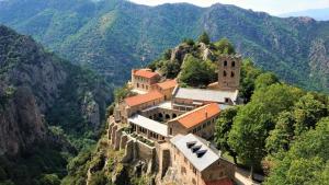 un bâtiment sur le côté d'une montagne dans l'établissement LE REFUGE DES CASCADES, à Vernet-les-Bains