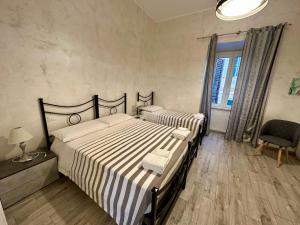 a bedroom with a bed and a chair and a window at NEWHOUSE ANTIUM in Anzio