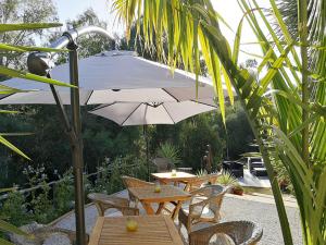 a patio with tables and chairs and an umbrella at Finca verde de la luz in Barbate