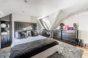 een slaapkamer met een groot bed en een dressoir bij Unique Gem in Kensington in Londen