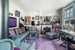 uma sala de estar com um sofá e uma mesa em Unique Gem in Kensington em Londres