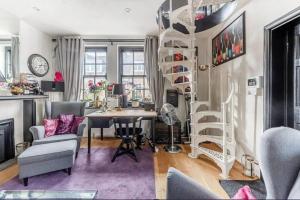 een kamer met een bureau en een wenteltrap bij Unique Gem in Kensington in Londen