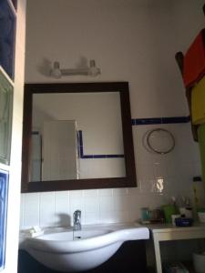 uma casa de banho com um espelho grande e um lavatório em Villa Cuatro Encinas, Iznájar em Iznájar