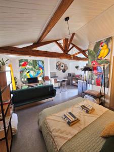 a room with a bed and a living room with paintings at Gite "RIO", parking securise in La Roche-sur-Yon