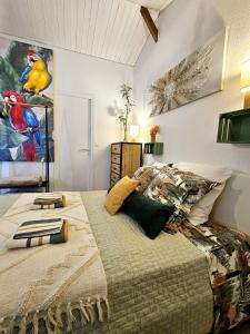 a bedroom with a bed with a bird painting on the wall at Gite "RIO", parking securise in La Roche-sur-Yon