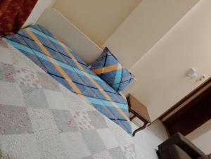 a bed with blue and orange pillows in a room at All in One in Sharjah
