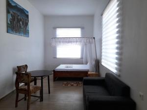 sala de estar con sofá, mesa y cama en La-Domek Traveller's home, en Mbeya