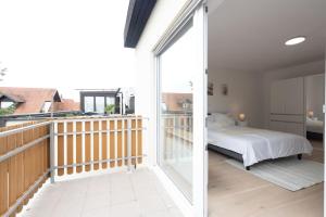 1 dormitorio con 1 cama y balcón en Stylish Apartment near Munich, en Moorenweis