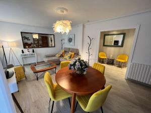 a living room with a table and yellow chairs at Apartamenticos La Paz I in Zaragoza