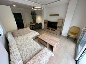 een woonkamer met een bank en een tafel bij Maison Rivière in Lefkada