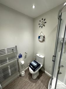 a bathroom with a toilet with a clock on the wall at Nautical South Self-contained Dog Friendly Annexe in Fareham