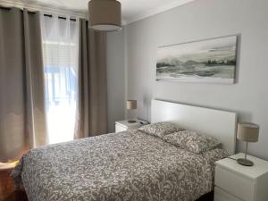 um quarto com uma cama, 2 candeeiros e uma janela em Mar à vista - Seaview apartment em Ericeira