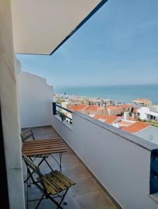 een balkon met een tafel en stoelen in een gebouw bij Mar à vista - Seaview apartment in Ericeira