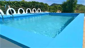 una piscina azul con sillas en el agua en Es Marroig, en Llucmajor