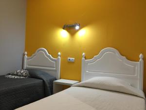 
a bedroom with two beds and two lamps at Guest House Sao Filipe in Faro
