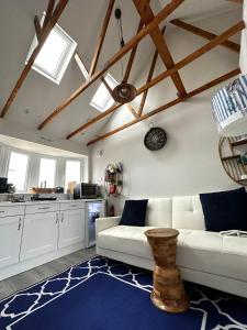a living room with a white couch and a blue rug at Nautical South Self-contained Dog Friendly Annexe in Fareham