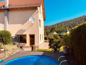 a house with a swimming pool in front of a house at Ferienwohnung Etzelbach in Etzelbach