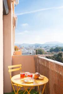 a small yellow table and chairs on a balcony at Appartement Plage Prado avec parking in Marseille