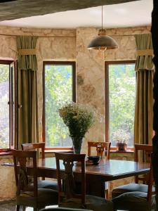 a dining room with a table and two windows at Hotel Nordmann,Racha in Ambrolauri