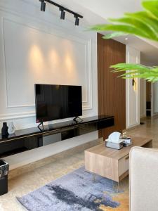 a living room with a flat screen tv on a wall at Insta-worthy staycation at 2BR luxury Apt - Podomoro Empire Tower in Medan