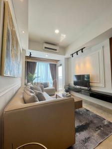 een grote woonkamer met een bank en een tv bij Insta-worthy staycation at 2BR luxury Apt - Podomoro Empire Tower in Medan