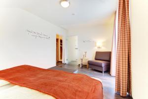 una camera da letto con un letto e un divano in una stanza di Ferienwohnungen Gästehaus Gaiser a Baiersbronn