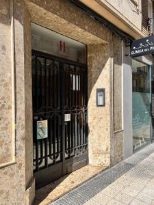 una tienda frente con una puerta negra en una calle en Apartamenticos La Paz I, en Zaragoza