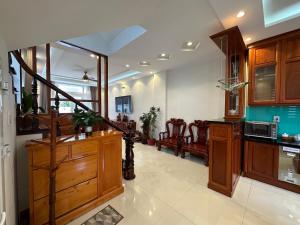 a large kitchen with wooden cabinets and a staircase at Đà Lạt Villa 84 Hồ Xuân Hương in Da Lat