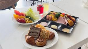 a white table with two plates of food on it at Watermark Hotel Kyoto HIS Hotel Group in Kyoto