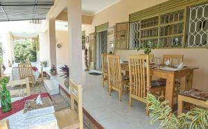 Cycad Entebbe Guest House في عنتيبي: مطبخ وغرفة طعام مع طاولة وكراسي