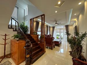 a living room with a staircase and some plants at Đà Lạt Villa 84 Hồ Xuân Hương in Da Lat