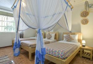 Rúm í herbergi á Cycad Entebbe Guest House