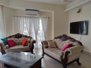 sala de estar con 2 sofás y TV en The Ganges View Luxury Penthouse by iTvara en Rishīkesh