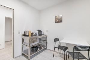 une cuisine avec une table, deux chaises et un four micro-ondes dans l'établissement Unterkunft in Bergkamen, à Bergkamen