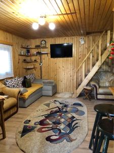a living room with a couch and a tv on a wall at Inchirieri cabana- “Chalet Rustique” in Covasna