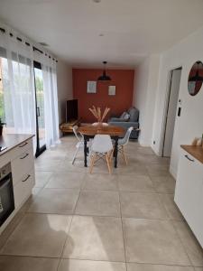 cocina y sala de estar con mesa y sillas en Appart moderne avec jardin à 5min de la plage, en Sainte-Marie-la-Mer